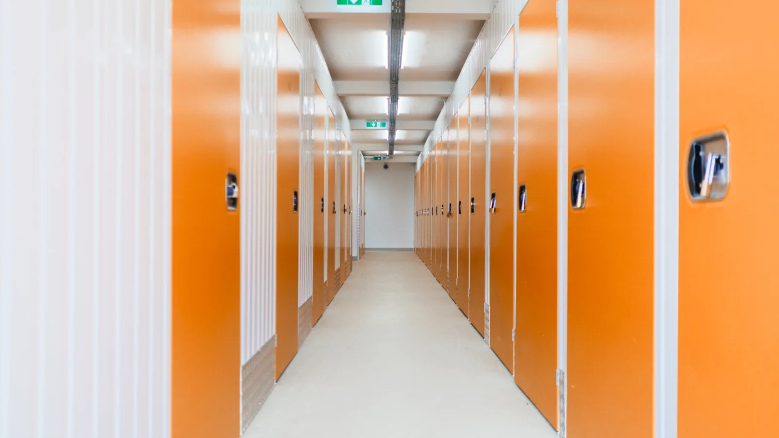 Korridor mit signal-orangen Boxentüren in unterschiedlichen Größen im Selfstorage-Gebäude Erfurt