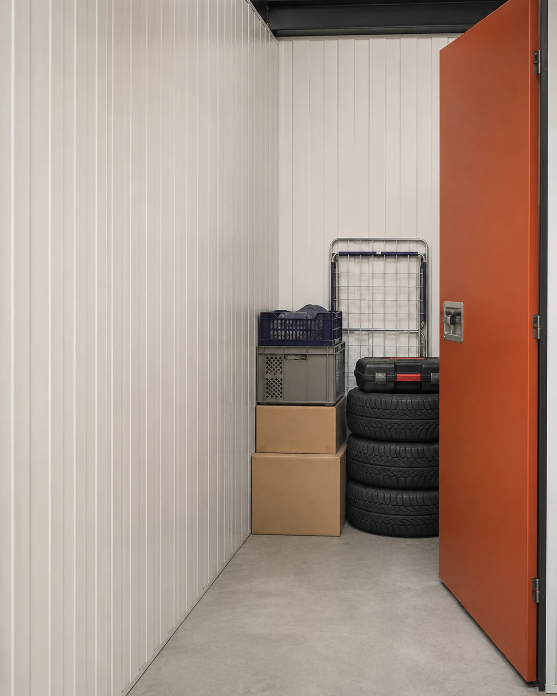 Kleine aufgeräumte Lagerbox mit Saison-Kartons und einem Reifenstapel