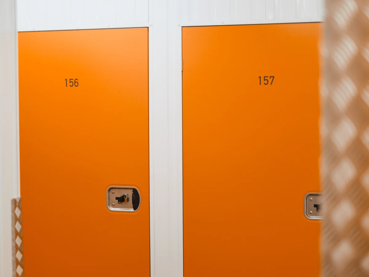 Zwei orangefarbene Boxtüren mit den aufgedruckten Nummern 156 und 157
